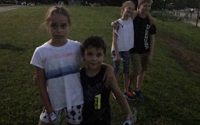 Four children standing on the grass as the light drops during the 2017 eclipse