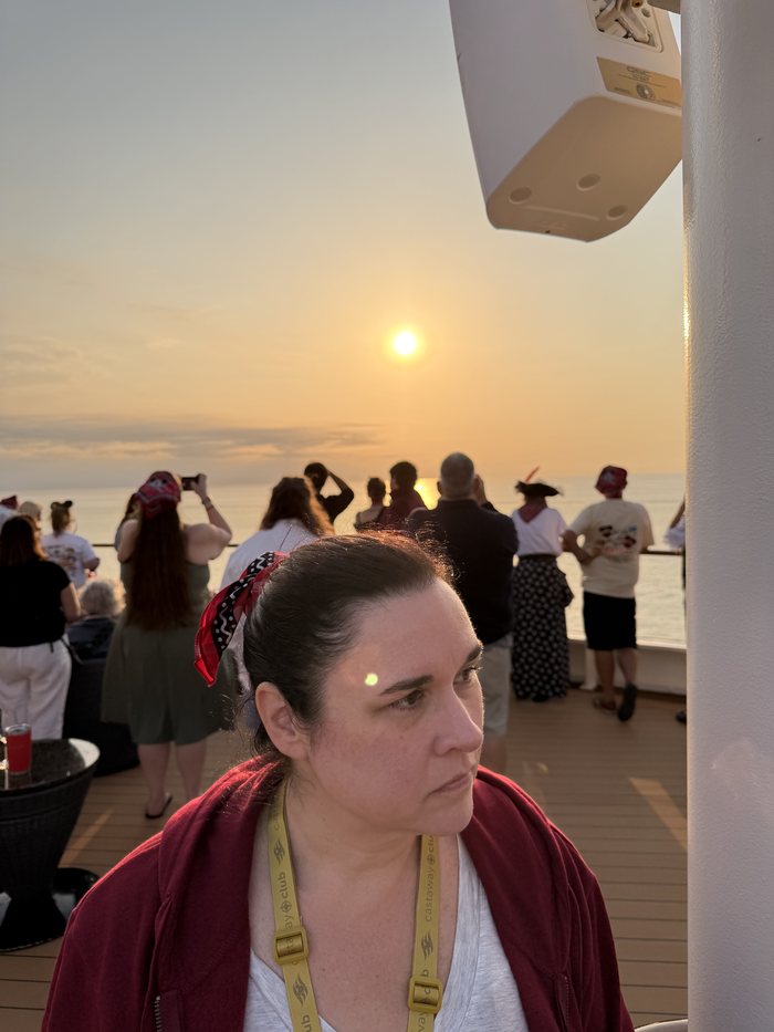 Passengers lining the ship rail watching the eclipsed sun over the water