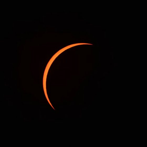 The sun as a razor-thin sliver of orange light
