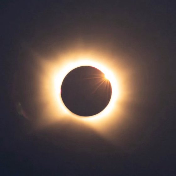 The diamond ring effect, a single bright bead on the edge of the dark moon